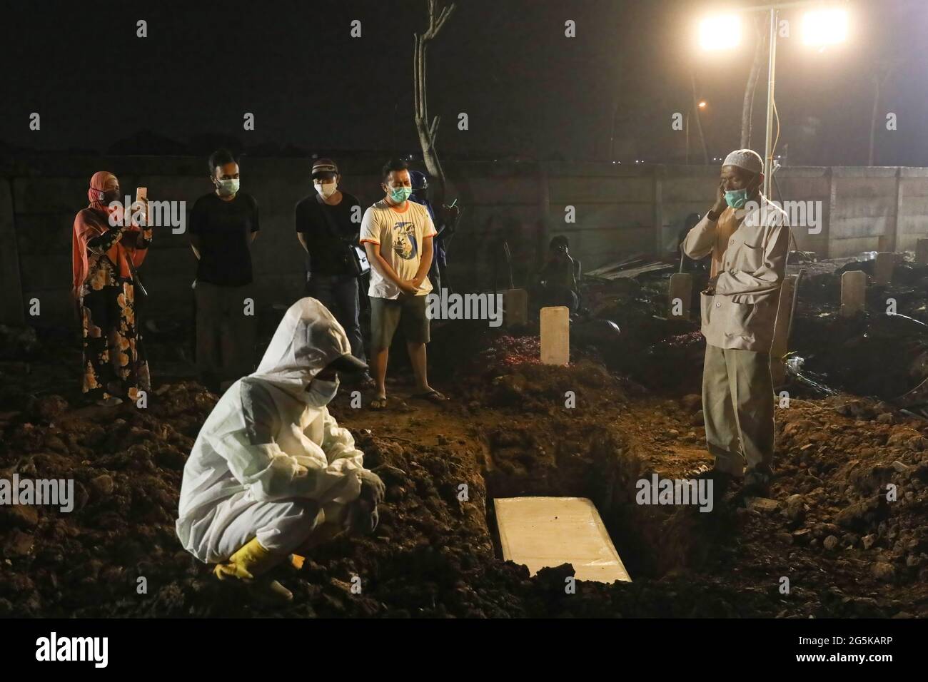 Nord-Jakarta, Indonesien. Juni 2021. Verwandte beten für den Leichnam von Covid-19, der auf dem öffentlichen Friedhof von Rorotan begraben ist. Der Trend der täglichen Covid-19-Fälle in Indonesien hat seit Anfang Juni 2021 zugenommen. (Foto: Jovan TRINITI/SOPA Images/Sipa USA) Quelle: SIPA USA/Alamy Live News Stockfoto