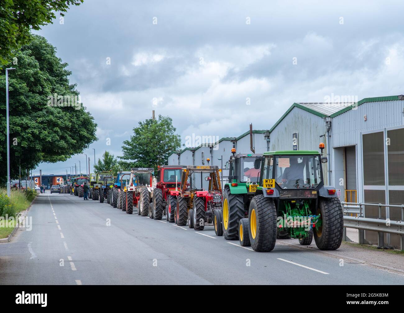 27. Juni 2021 - Pocklington, East Yorkshire, UK - Beacon Young Farmers Club Tractor Run. Die Linie der geparkten Traktoren auf dem Industriegelände. Stockfoto