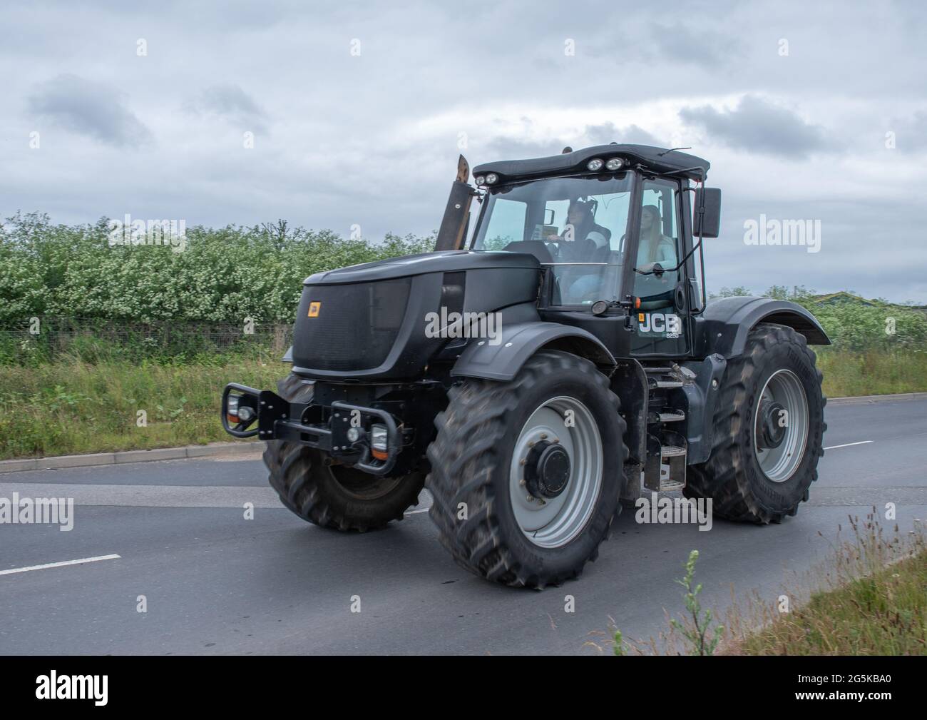 27. Juni 2021 - Pocklington, East Yorkshire, UK - Beacon Young Farmers Club Tractor Run. Schwarz und grau großer Traktor auf der Autobahn. Stockfoto