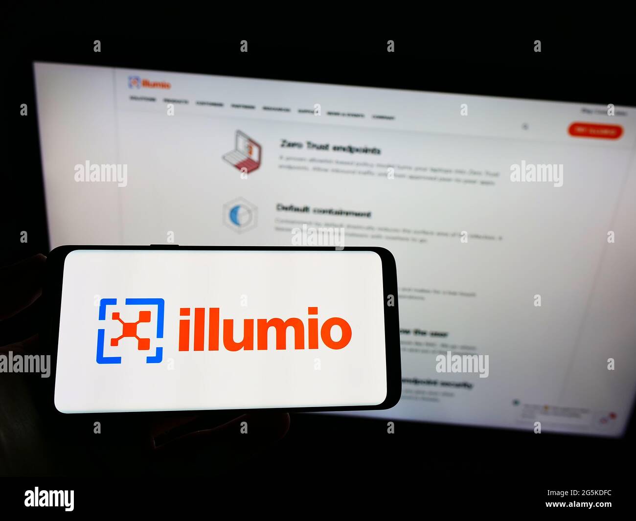 Person, die Mobiltelefon mit dem Logo des amerikanischen Cloud-Computing-Sicherheitsunternehmens Illumio Inc. Auf dem Bildschirm vor der Webseite hält. Konzentrieren Sie sich auf die Telefonanzeige. Stockfoto