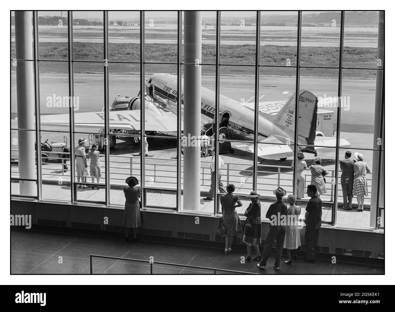 Airport Terminal 1940er Jahre American Airline Travel USA Eastern Airlines Silverliner DC3-Linienflugzeuge auf dem Asphalt mit Besuchern, die die Aktivität durch das Fenster des Wartezimmers der Abflughalle beobachten. Städtischer Flughafen, Washington, DC von Jack Delano, Fotograf 1941. Juli. 2. Weltkrieg - Vereinigte Staaten--District of Columbia--Washington (D.C.) Stockfoto