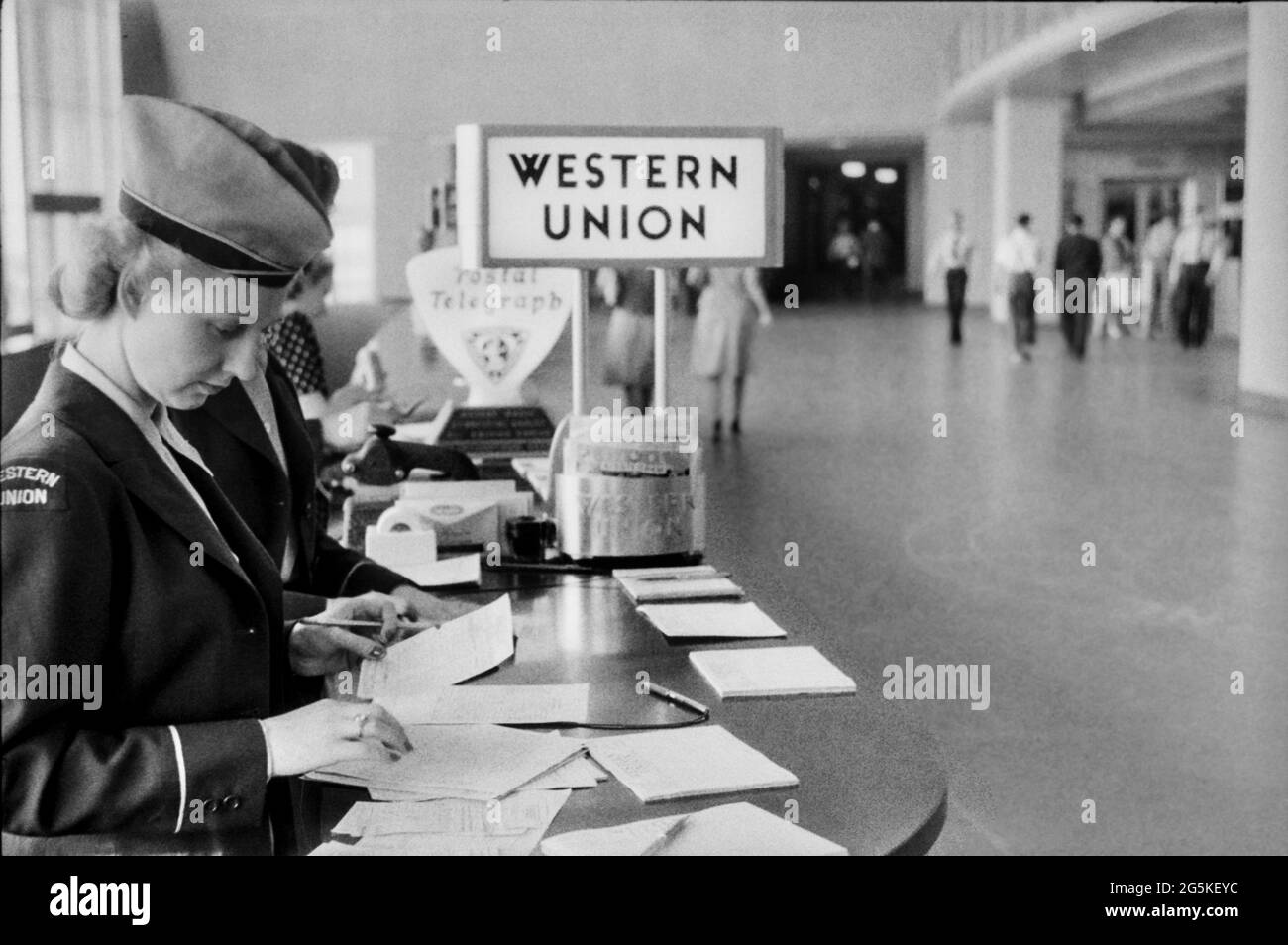 Vintage 1940er Airport Western Union Schalter und uniformierte Mitarbeiter am städtischen Flughafenterminal in der Nähe von Passagieren in Washington, DC, Jack Delano Fotograf LOC war Administration [1941. Juli] Vereinigte Staaten--District of Columbia--Washington (D.C.) USA Stockfoto