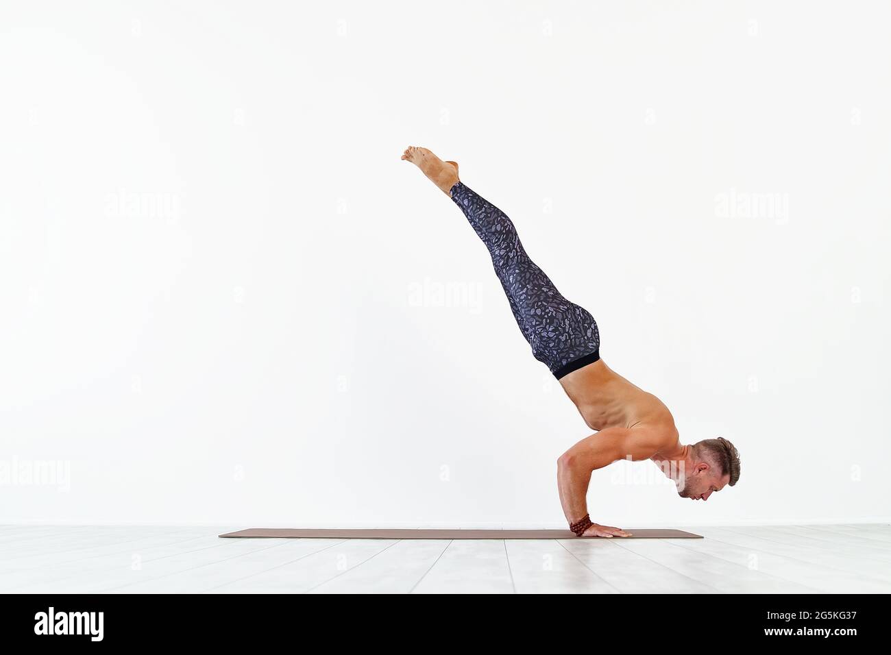 Junger Mann Akrobatik Gymnastik tun ein Handstand Studio isoliert auf weißem Hintergrund, athletische Sportler Stockfoto