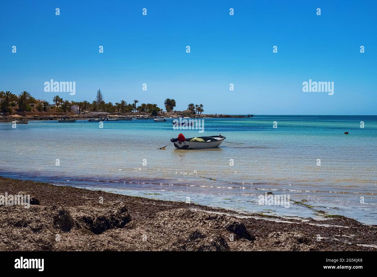 Herrliche Aussicht auf die Mittelmeerküste mit Birkenwasser, weißem Sandstrand und einem Fischerboot Stockfoto