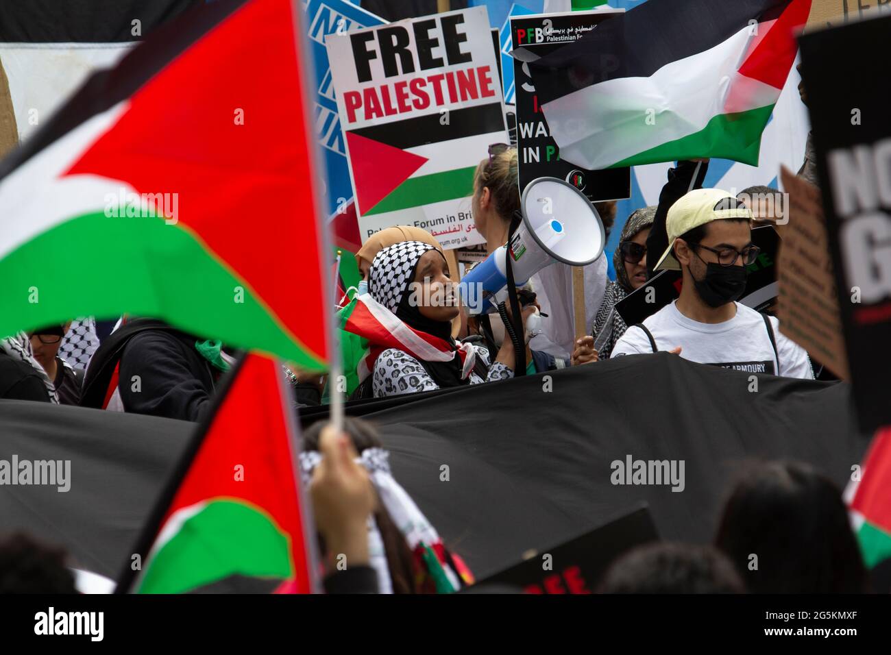 Proteste in London, Aktivisten protestieren in Zentral-London vor der National Demonstration der Volksversammlung, Demonstranten für freies Palästina, junger Aktivist mit Megaphon im Zentrum Stockfoto