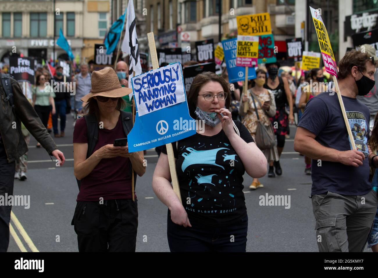 Proteste in London, Aktivisten protestieren in Zentral-London vor der Volksversammlung Nationale Demonstration weiblich mit ernsthaft nervender Frau, Kampagne für nukleare Abrüstung Plakat Stockfoto