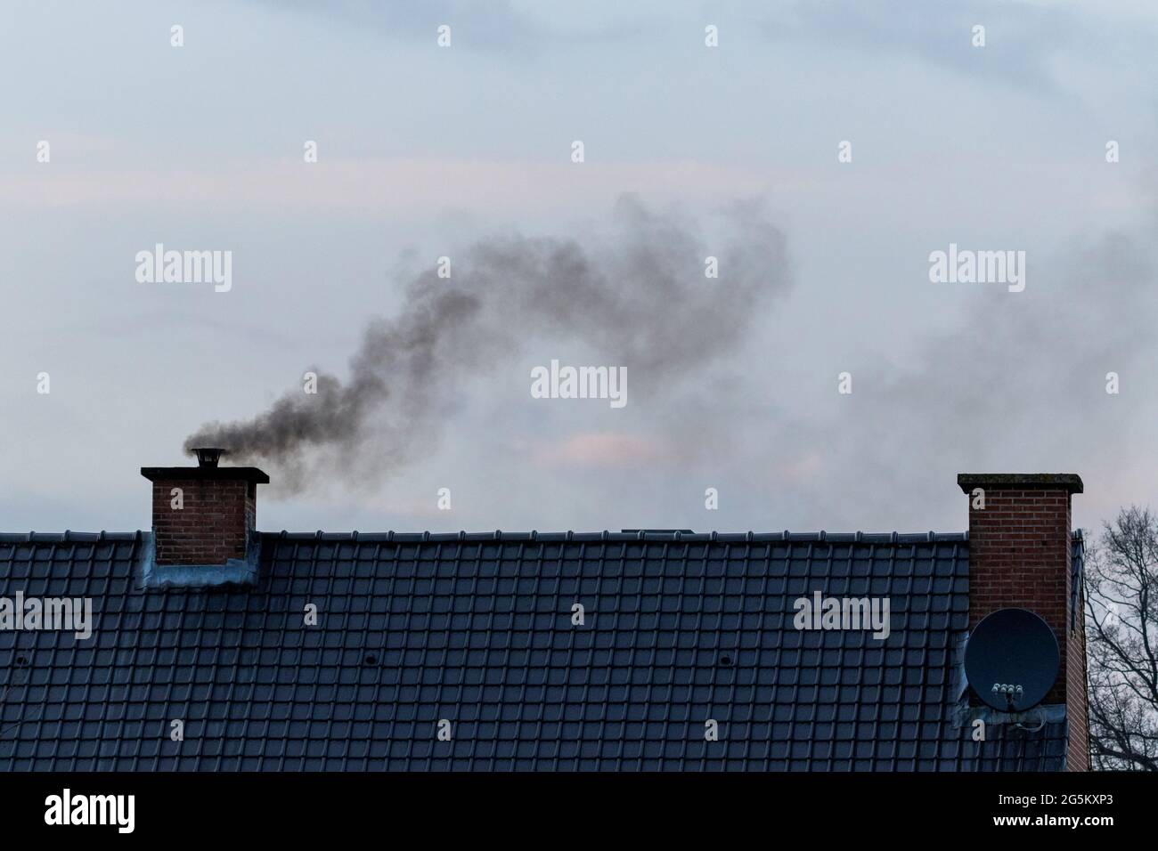 Kamin Rauch Drückt In Die Wohnung Ein Dach mit zwei Schornsteinen darauf. In einem der Kamine ist ein