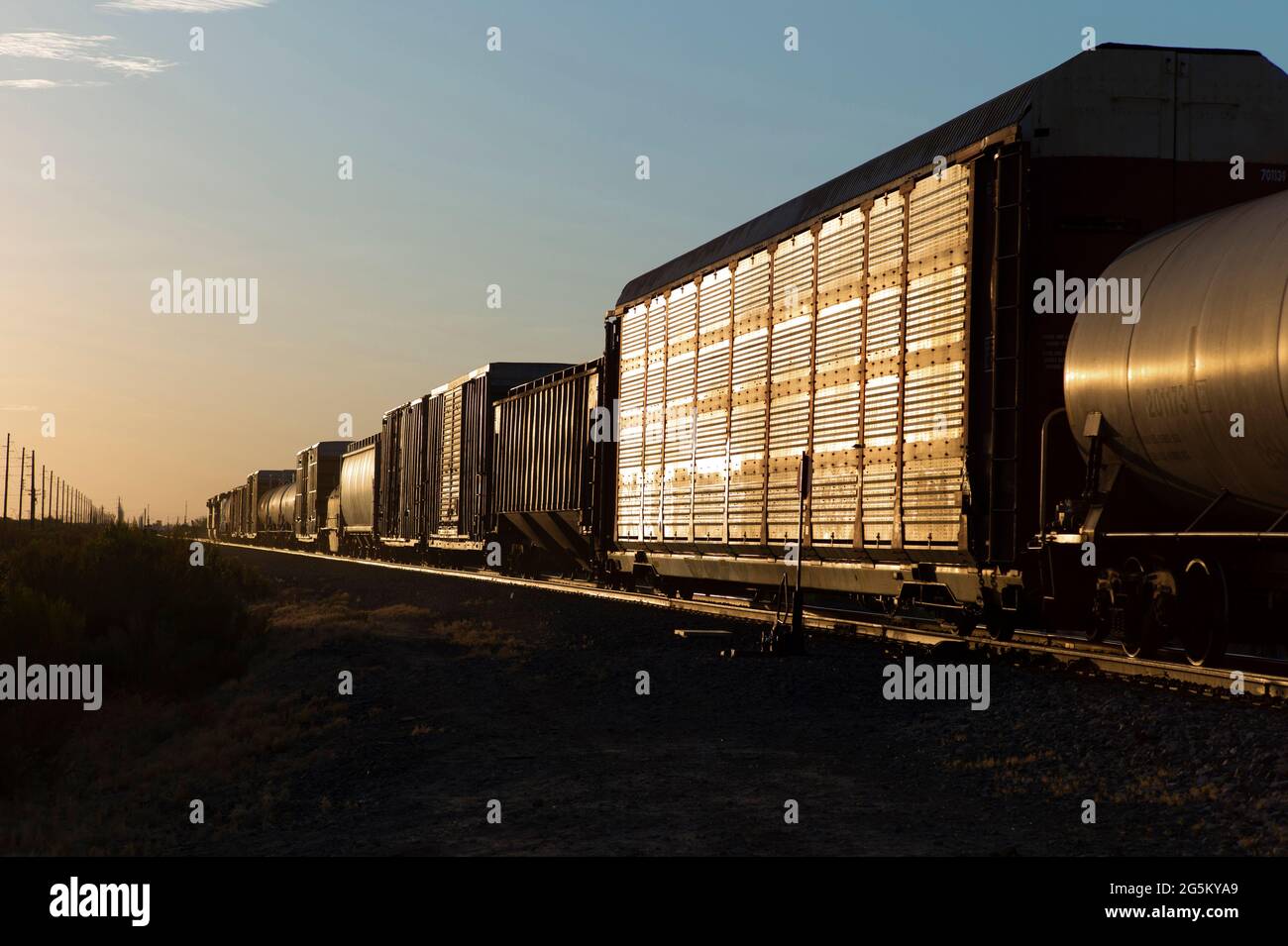Ein Güterzug rollt in den Sonnenuntergang in der Wüste von Arizona. Stockfoto