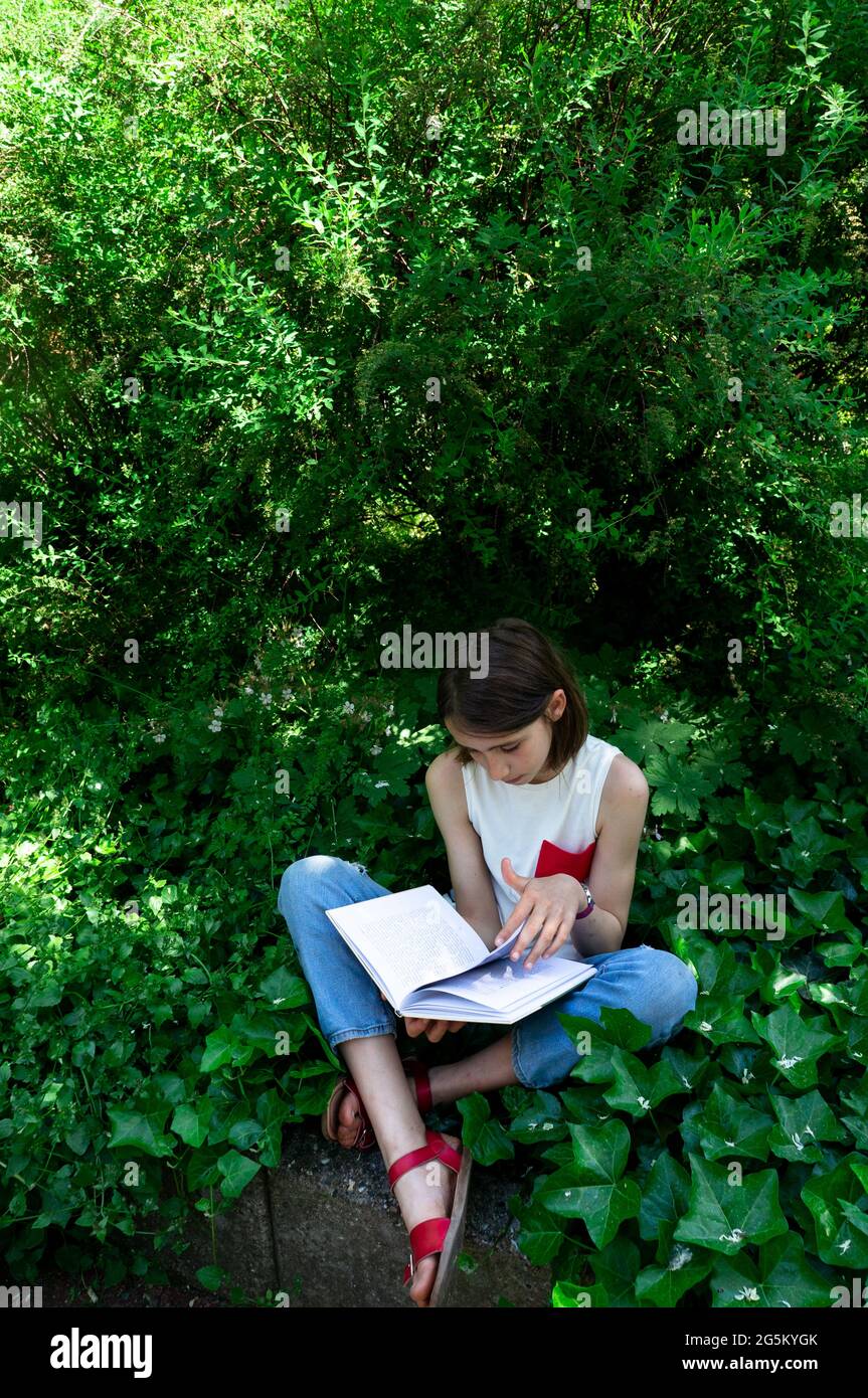 Mädchen lesen ein Buch im Garten Stockfoto