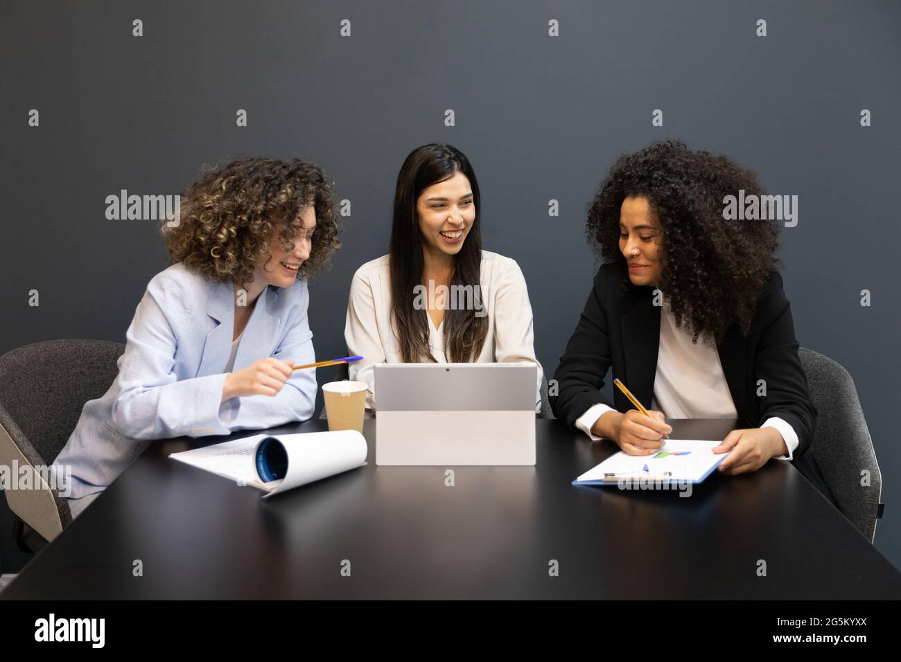 Fokussierte multikulturelle Geschäftsfrauen, die während eines Meetings zusammenarbeiten. Stockfoto