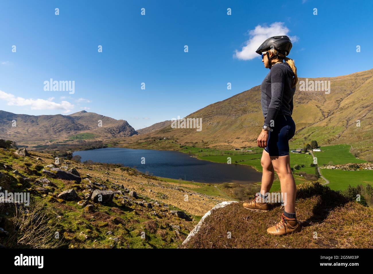 Eine Radfahrerin bewundert die Berglandschaft im Gap of Dunloe Kerry mou Stockfoto