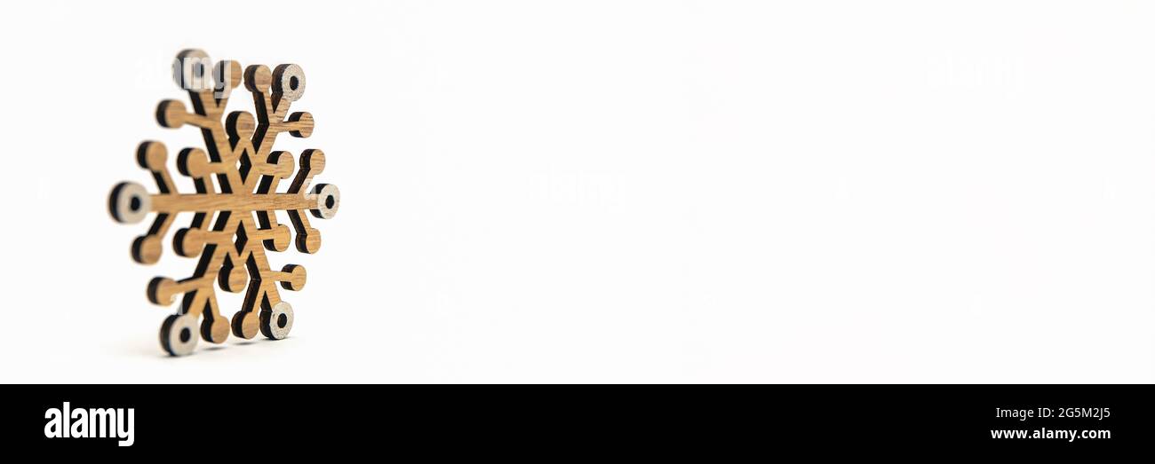 Schneeflocke auf weißem Hintergrund. Hölzerne Schneeflocken werfen Schatten auf weißen isolierten Hintergrund. Bedruckbares Banner, Modell für weihnachtskarte, Platz für te Stockfoto