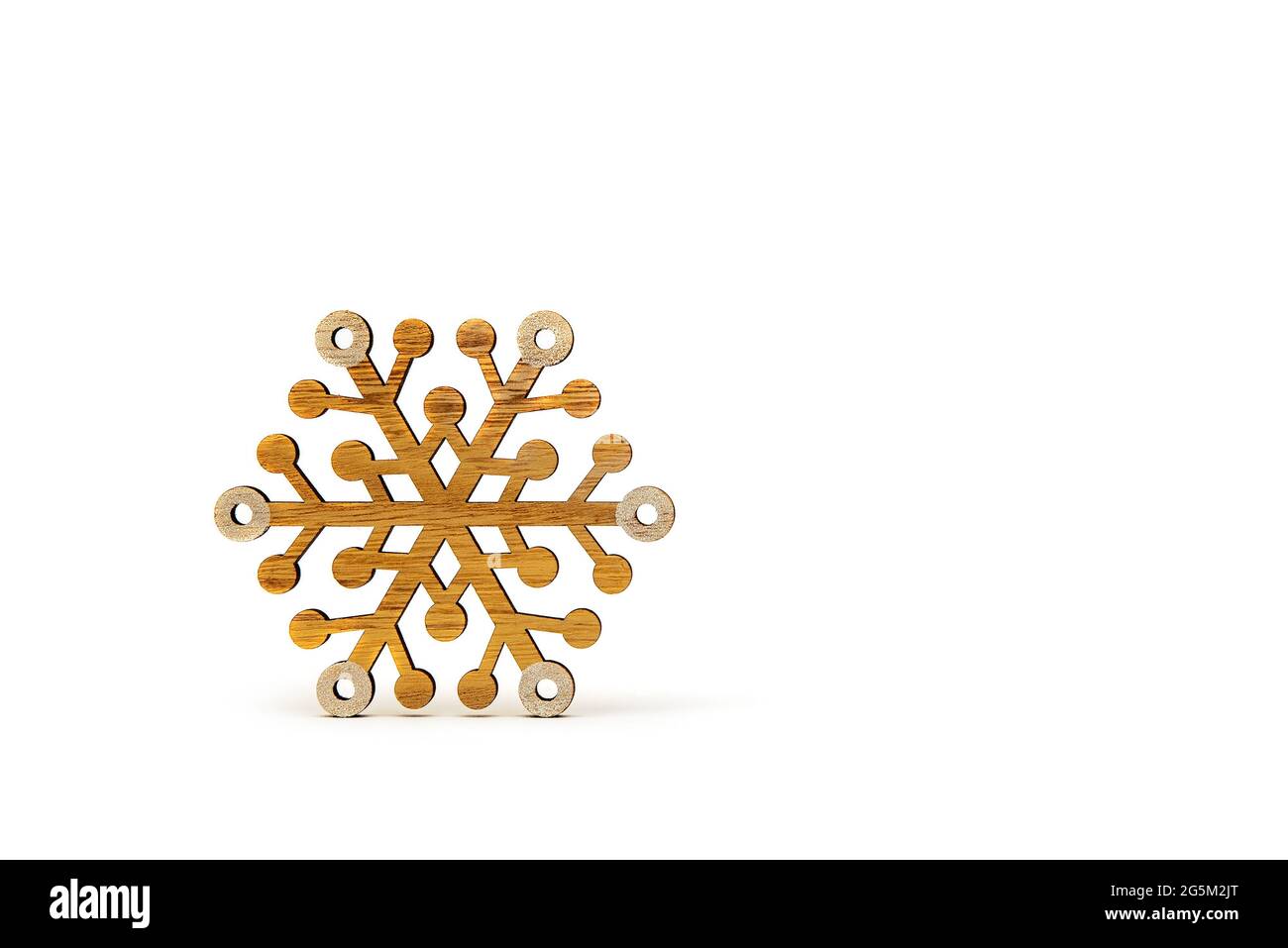Schneeflocke auf weißem Hintergrund. Hölzerne Schneeflocken werfen Schatten auf weißen isolierten Hintergrund. Bedruckbares Banner, Modell für weihnachtskarte, Platz für te Stockfoto