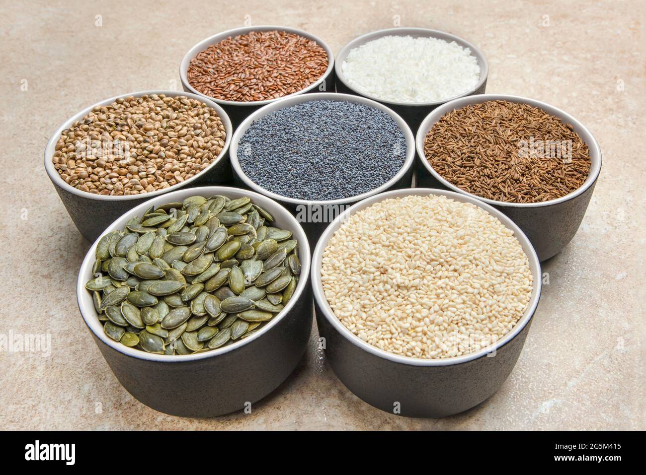 Verschiedene Samen auf Marmorboden. Sortiment, Saatgutset, gesunde Lebensmittelzutaten, Superfoods, Kopierraum. Sonnenblume, Flachs, Kürbis, Cannabis Stockfoto