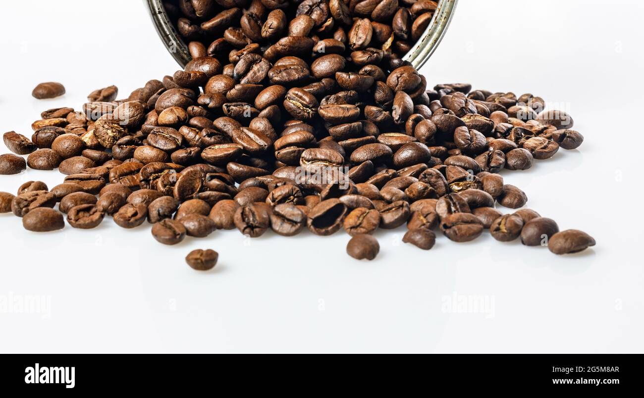 Lebensmittelbanner. Offene Blechdose und Körner schwarzen Kaffees auf weißem Hintergrund. Duftende geröstete arabica-Bohnen auf einem weißen Tisch. Traditionelles Morgengetränk Stockfoto