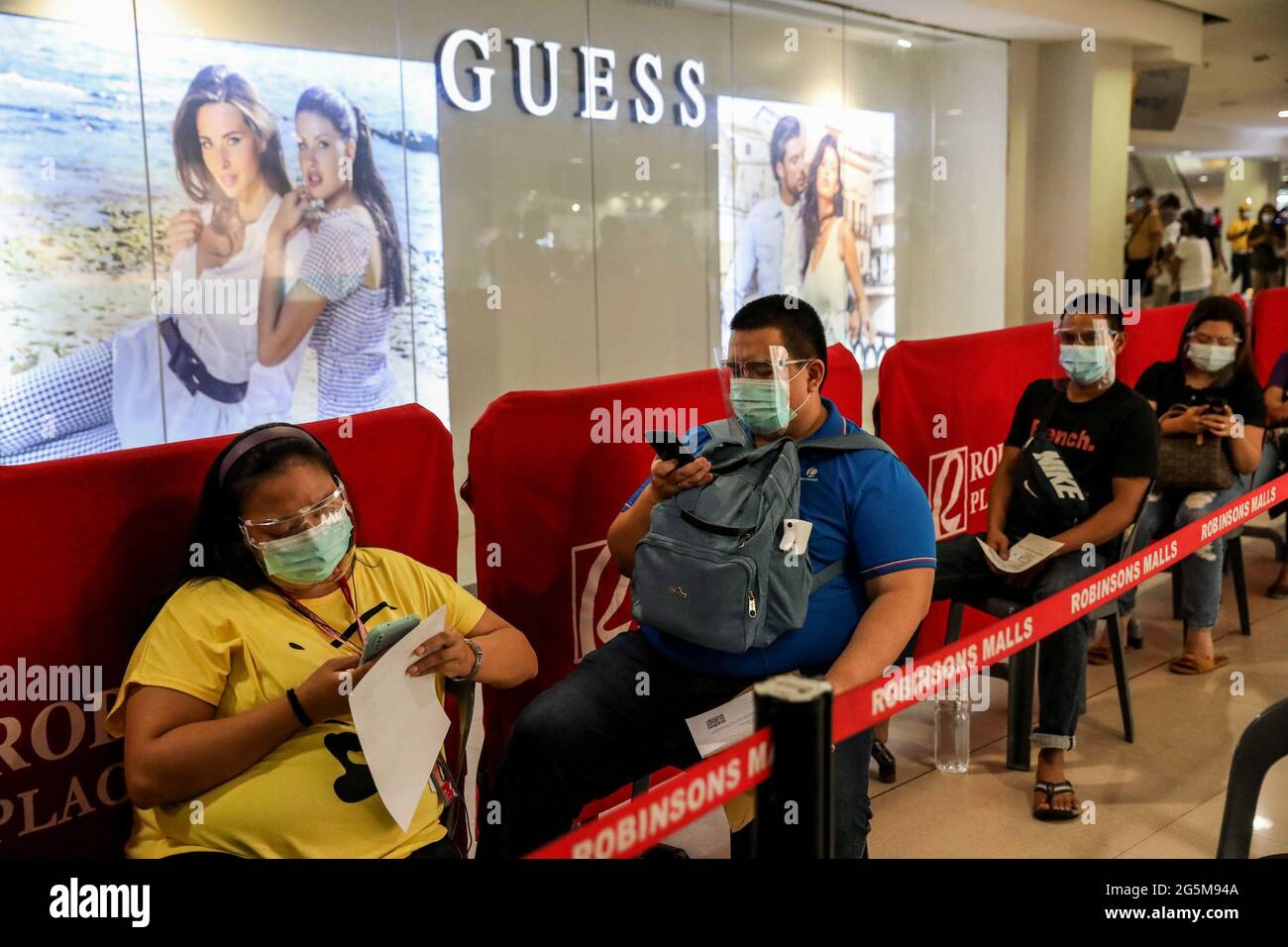 In einer Mall in Manila, Philippinen, wurden Patienten mit dem Sinovac-Impfstoff COVID-19 geimpft, während sich die Menschen in der Schlange anstellen, während Gesundheitsarbeiter Patienten mit dem Sinovac-Impfstoff COVID- impfen. Stockfoto
