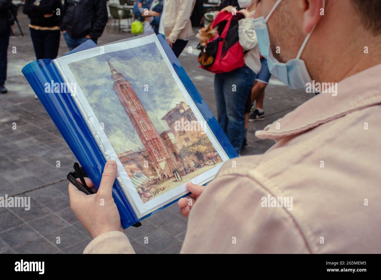 Zaragoza, Spanien - 23,2021. Juni: Touristen beobachten ein altes Bild aus der Stadt Zaragoza. Touristen, die wegen einer COVID-Pandemie eine Maske tragen Stockfoto