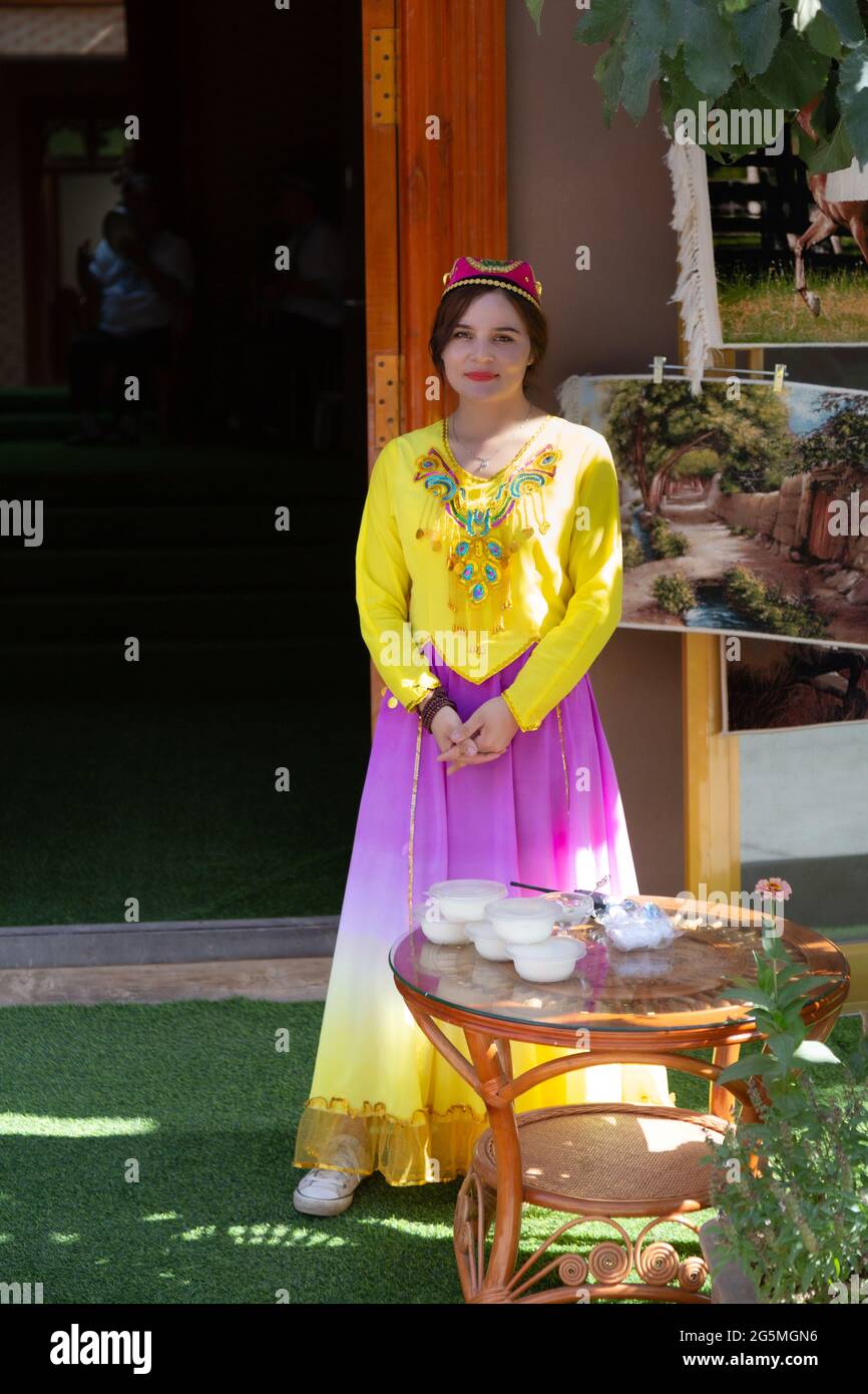 Eine junge Frau steht in ihrer traditionellen Kleidung vor einem Restaurant Stockfoto