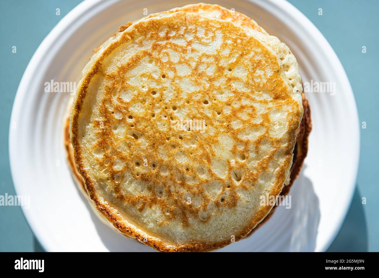 Makroaufnahme von oben, flache Ansicht von Stapel Buttermilch-Pfannkuchen auf dem Teller als traditionelles Frühstücksbrunch-Dessert Stockfoto