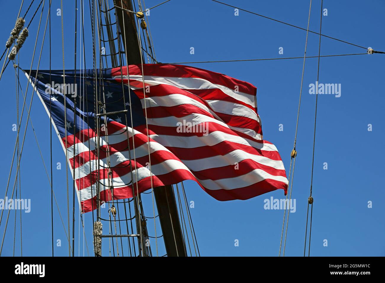 Eine amerikanische Flagge, die in einem Schiff gefangen wurde, seile und takelte. Stockfoto