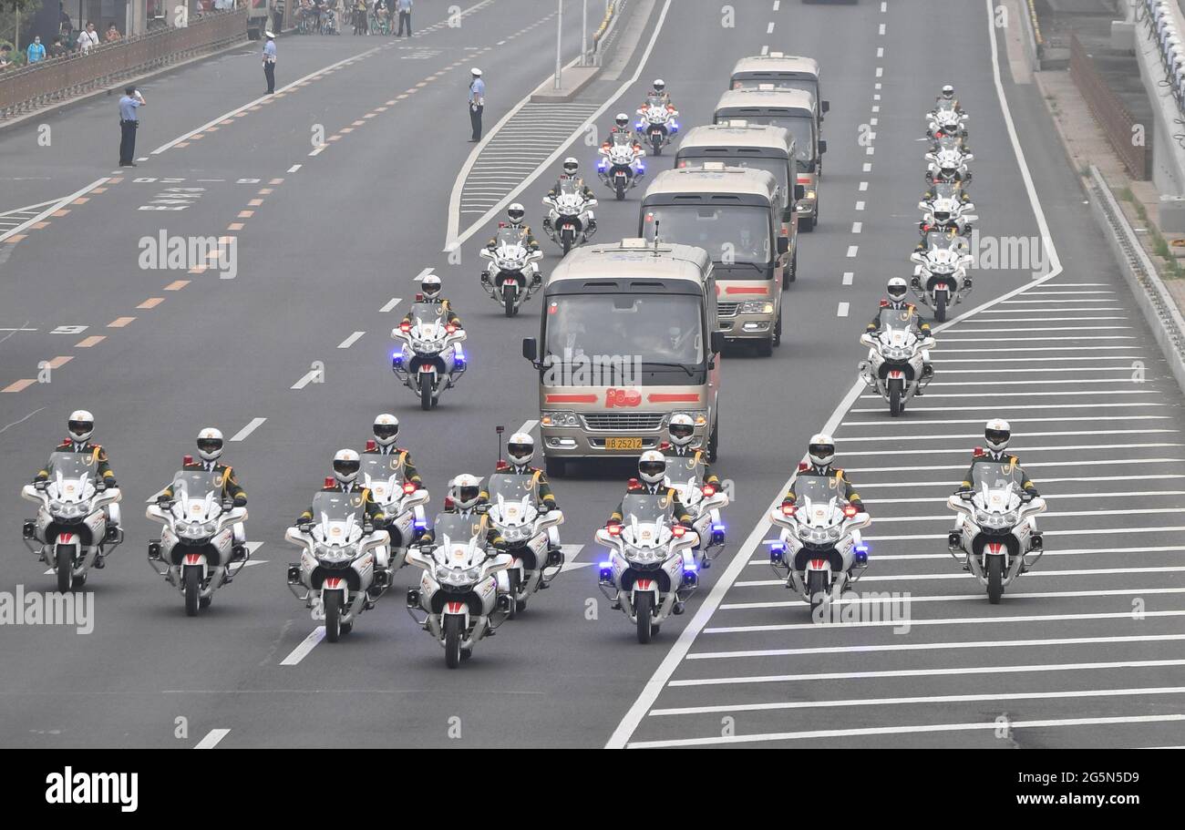 Peking, China. Juni 2021. Die Autokolonne, die Träger der Medaille vom 1. Juli ist, wird von Motorradbegleitern auf dem Weg zur Großen Halle des Volkes in Peking, der Hauptstadt Chinas, am 29. Juni 2021 begleitet. Am Dienstagmorgen wird eine Zeremonie stattfinden, um die Medaille vom 1. Juli, die höchste Auszeichnung in der Kommunistischen Partei Chinas (KPCh), zum ersten Mal an herausragende Parteimitglieder zu vergeben. Die Zeremonie wird in der Großen Halle des Volkes in Peking stattfinden. Quelle: Zhai Jianlan/Xinhua/Alamy Live News Stockfoto