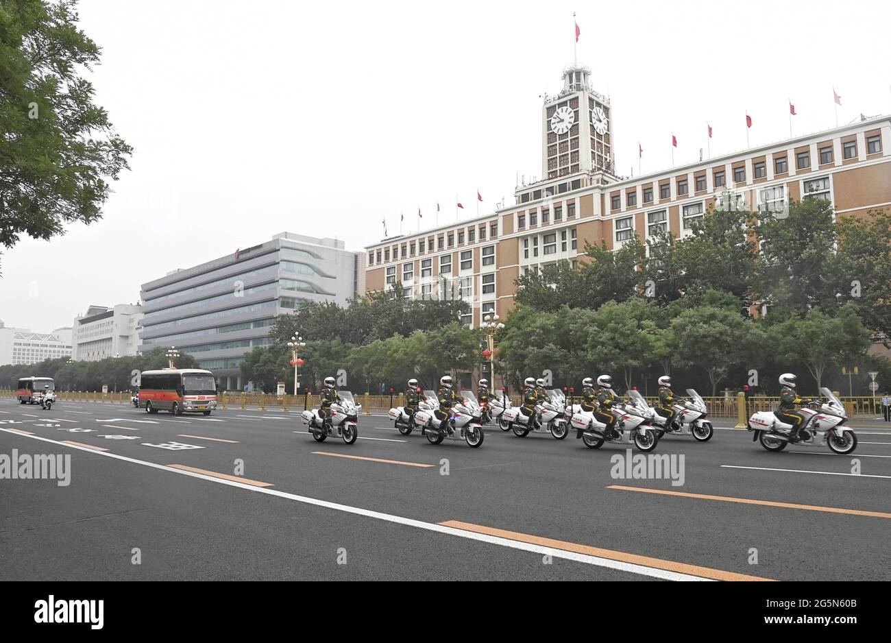 Peking, China. Juni 2021. Die Autokolonne, die Träger der Medaille vom 1. Juli ist, wird von Motorradbegleitern auf dem Weg zur Großen Halle des Volkes in Peking, der Hauptstadt Chinas, am 29. Juni 2021 begleitet. Am Dienstagmorgen wird eine Zeremonie stattfinden, um die Medaille vom 1. Juli, die höchste Auszeichnung in der Kommunistischen Partei Chinas (KPCh), zum ersten Mal an herausragende Parteimitglieder zu vergeben. Die Zeremonie wird in der Großen Halle des Volkes in Peking stattfinden. Quelle: Jin Liangkuai/Xinhua/Alamy Live News Stockfoto