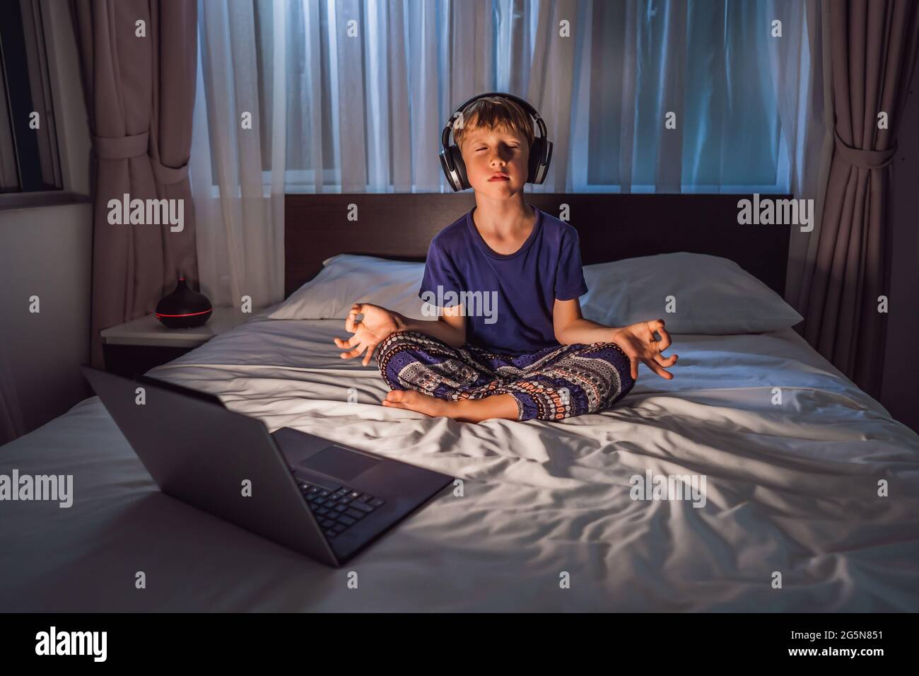 Boy meditiert auf dem Bett mit Meditation App. Sport, Technologie und  gesunde Lebensweise Konzept Stockfotografie - Alamy