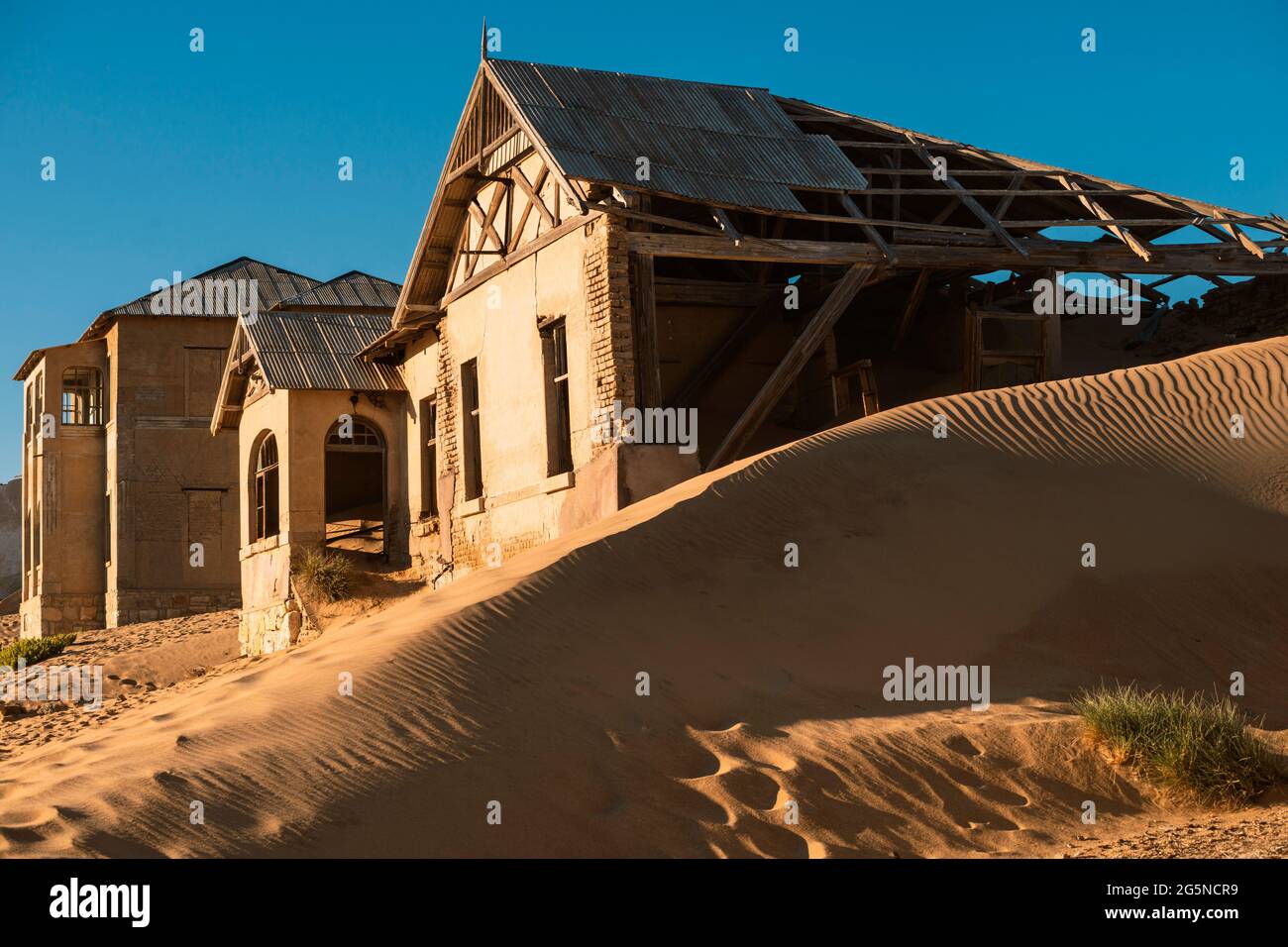Verlassene Ruinen der Stadt Kolmanskop zwischen Sanddünen in der Wüste Namibias am frühen Morgen Stockfoto