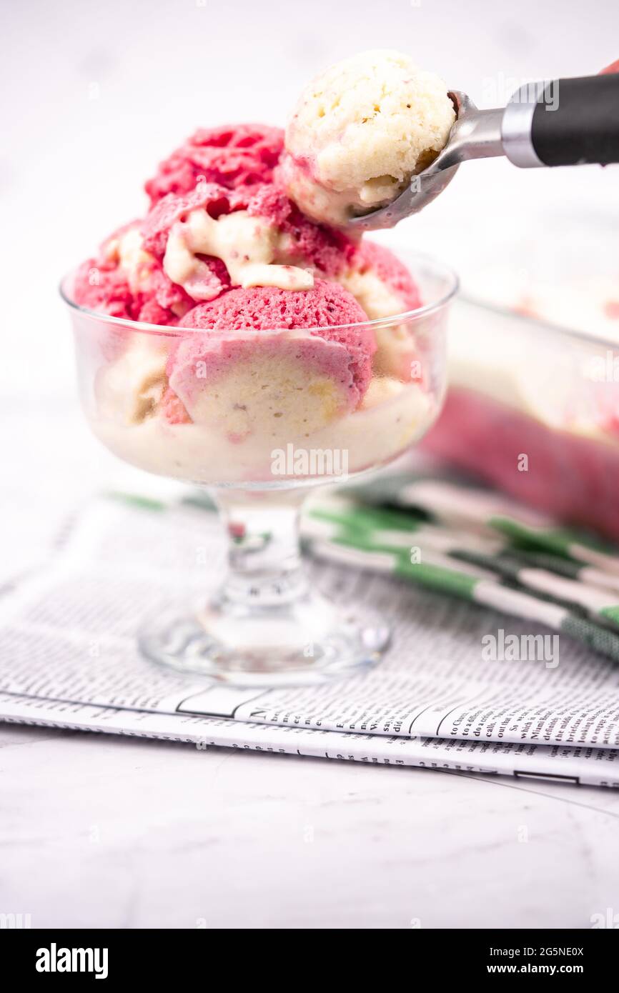Erdbeerjoghurt in Glasschüssel, Eiskugeln, Behälter mit hausgemachten Eisgläsern Stockfoto