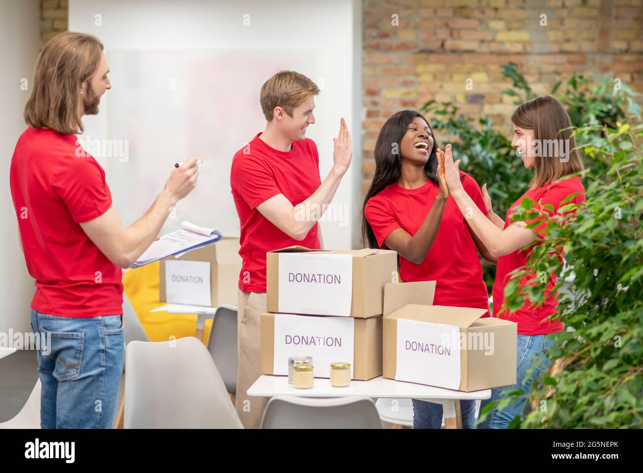 Junge Freiwillige, die in den Räumlichkeiten des Charity Center arbeiten Stockfoto