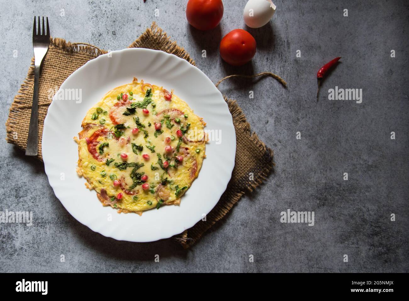 Käse-Tomatenomelett oder spanisches Omelett, zubereitet mit einer Eierbasis mit zusätzlichen Zutaten aus Käse, Pfeffer, Zwiebeln, Knoblauch und Tomaten. Stockfoto