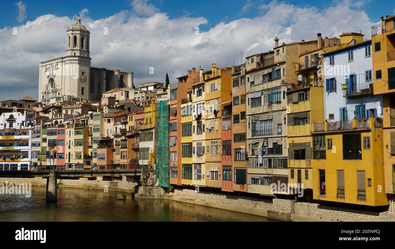 Ikonische Wasserfront mit Blick auf den Fluss Onyar, Girona, Cataluña, Spanien mit der Kathedrale in der Ferne. Stockfoto