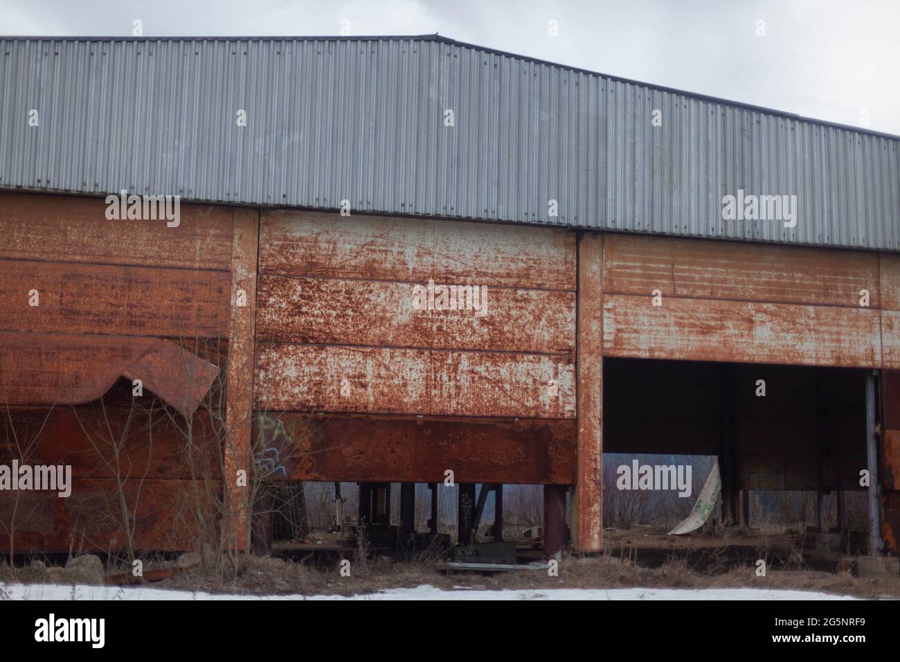 Verlassene Lagergebäude. Eine rostige Wand an einem großen Haus. Das Lager war lange Zeit leer. Verlassene Immobilien. Stockfoto