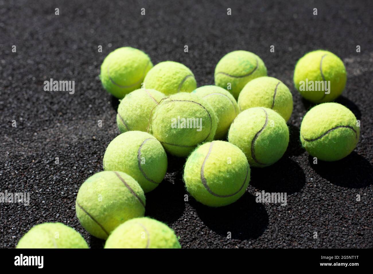 Tennisbälle. Die Kugeln liegen auf der Oberfläche des Spielplatzes. Tennis spielen mit einem Ball. Grüne weiche Kugeln für Schlägerangriffe. Stockfoto