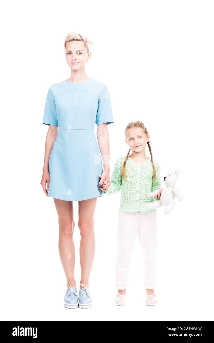 Vertikale Ganzlänge isoliert Aufnahme von schönen jungen erwachsenen Frau und ihre Tochter zusammen stehend Blick auf die Kamera, weißer Hintergrund Stockfoto