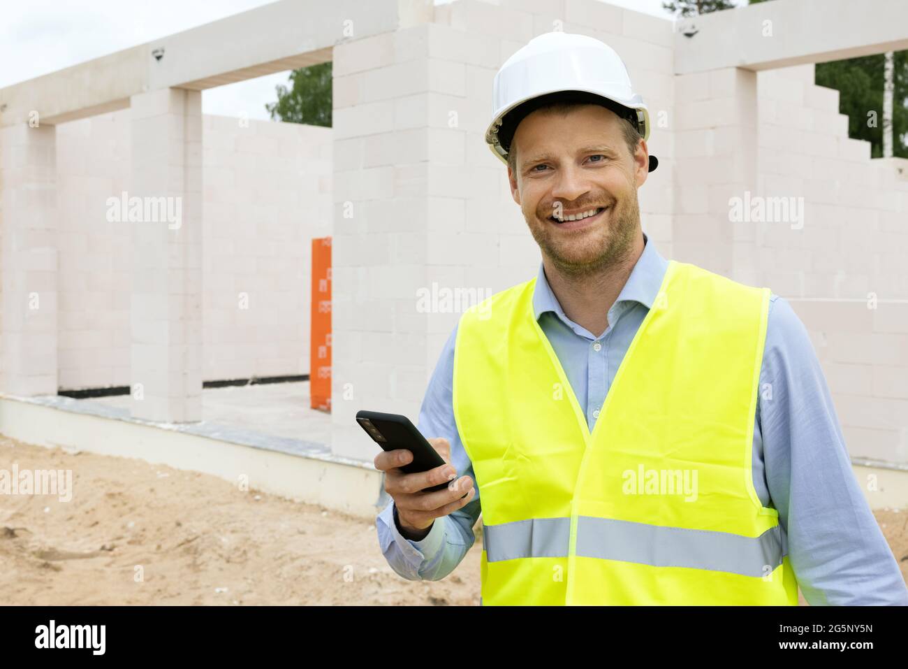 Lächelnder Bauingenieur auf der Baustelle. Projektüberwachung Stockfoto