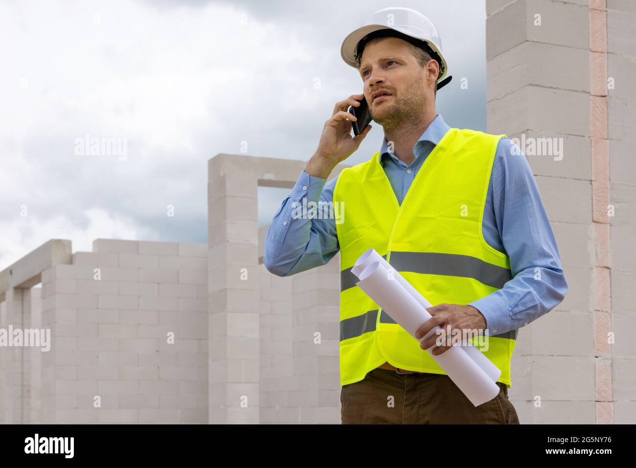 Bauingenieur Supervisor arbeitet auf der Baustelle. Telefongespräch Stockfoto