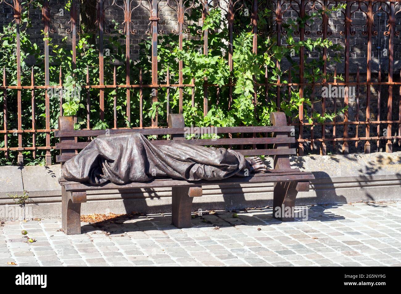 Skulptur eines obdachlosen Jesus, der auf einer Parkbank schläft Es ist eine Kopie eines Werkes in Toronto des kanadischen Bildhauers Timothy Schmalz - Bruges, Begium Stockfoto