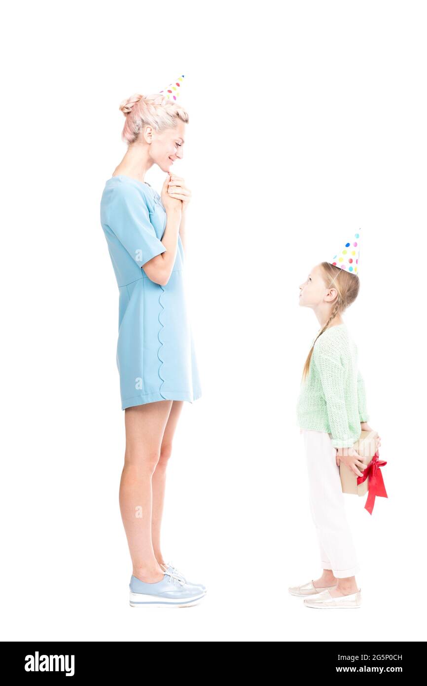 Vertikale voller Länge Seitenansicht Schuss von niedlichen kaukasischen Mädchen geben Geschenk-Box, um ihre glückliche Mutter, weißer Hintergrund Stockfoto