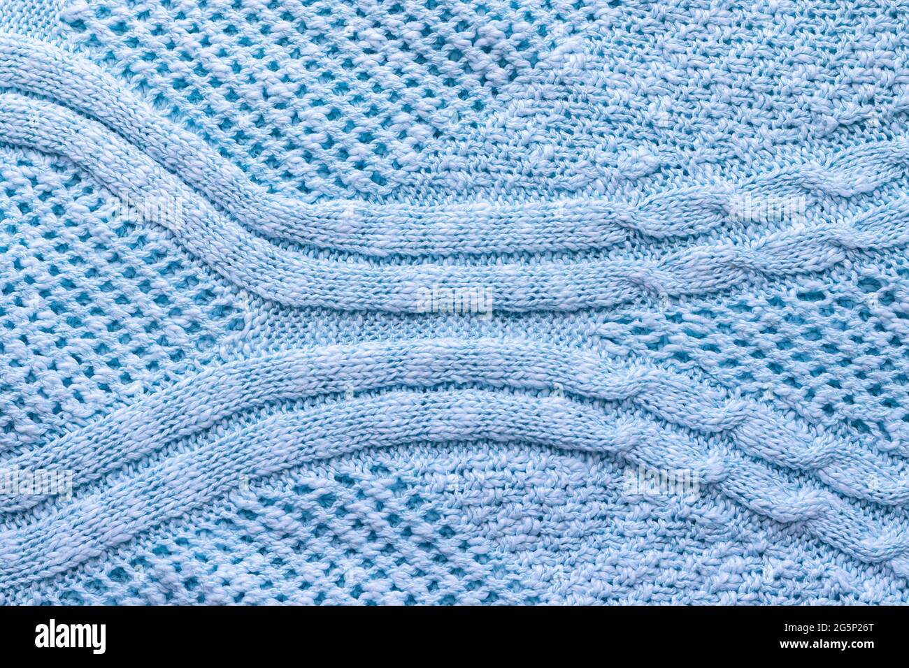 Knallblaue Strickstruktur. Rauer Pullover im Hintergrund. Nahaufnahme Stockfoto