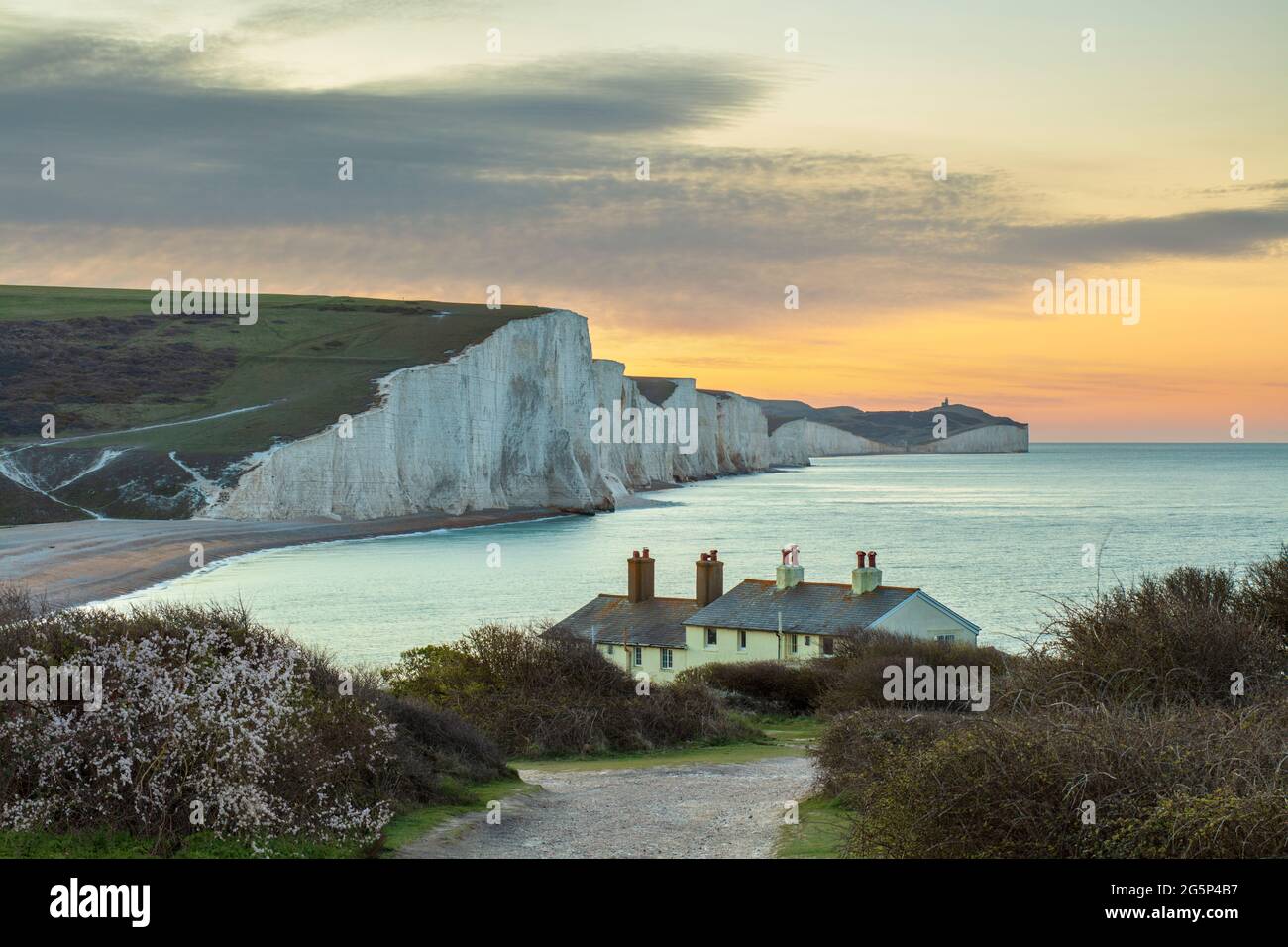 Seven Sisters und Beachy Head mit Küstenschutzhütten in Seaford Head bei Sonnenaufgang im Frühjahr, Seaford, East Sussex, England, Vereinigtes Königreich, Europa Stockfoto