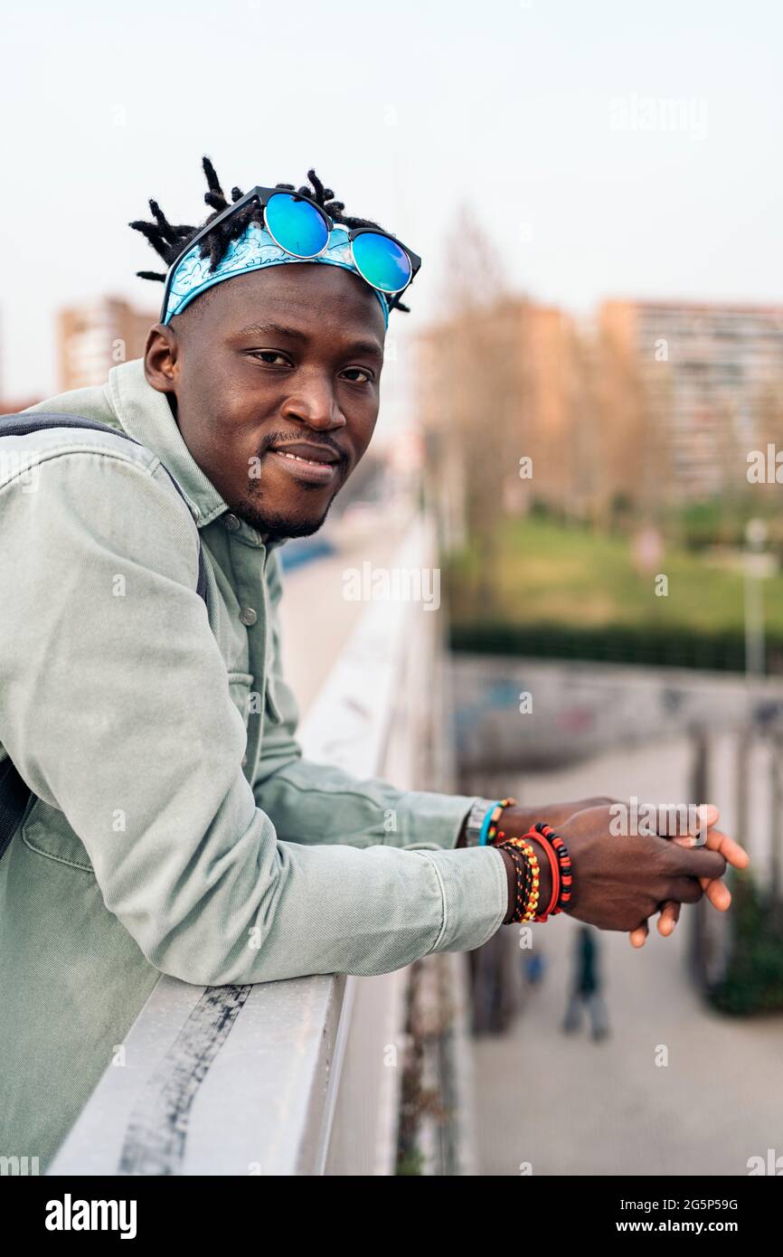 Junger und glücklicher afrikanischer Mann, der auf der Straße steht und die Kamera anschaut. Stockfoto