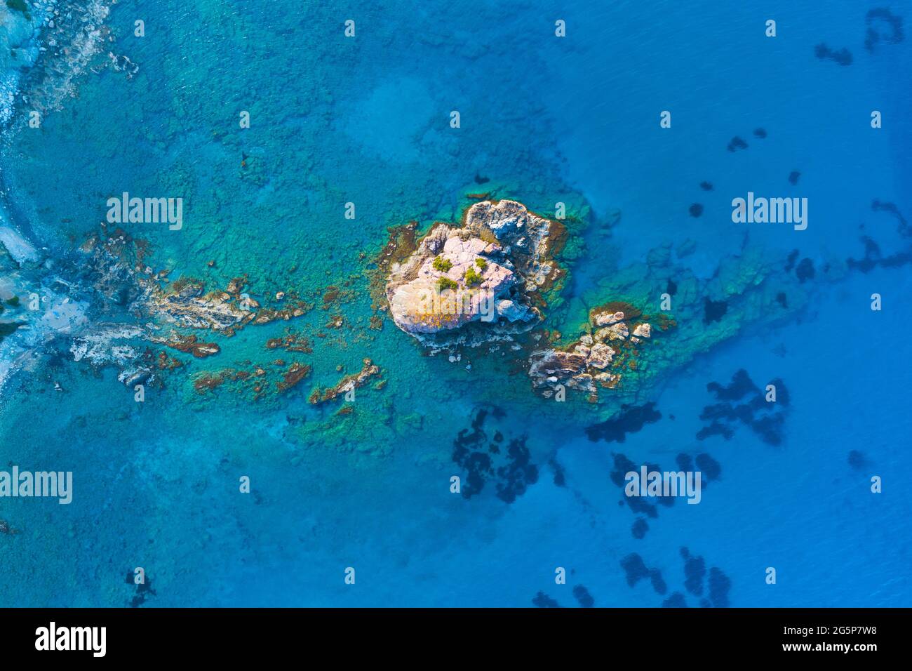 Insel und flaches Wasser im Blauen Ozean. Scharfe Klippe aus Stein. Felsiges Riff mit türkisfarbenem Wasser, Meereswellen auf wunderschönen Strand Luftaufnahme Drohne geschossen Stockfoto