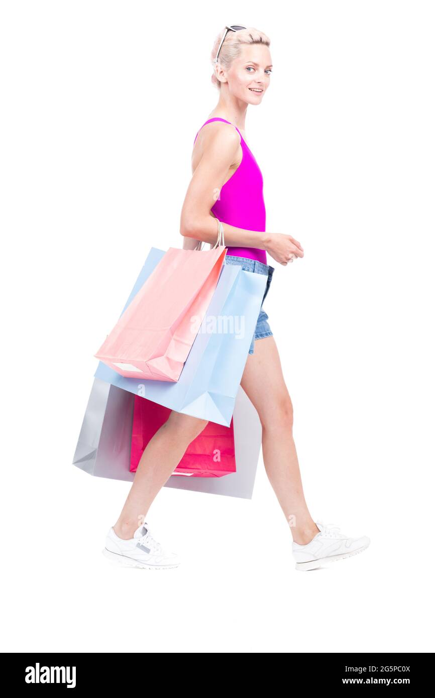 Vertikale volle Länge Studio Porträt von stilvollen jungen Frau trägt Sommer-Outfit mit Einkaufstaschen, weißem Hintergrund Stockfoto