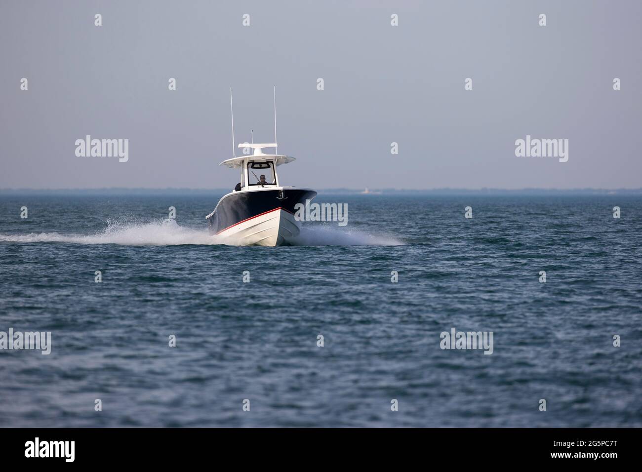 Motorboot, das allein auf einem leeren See fährt. Stockfoto