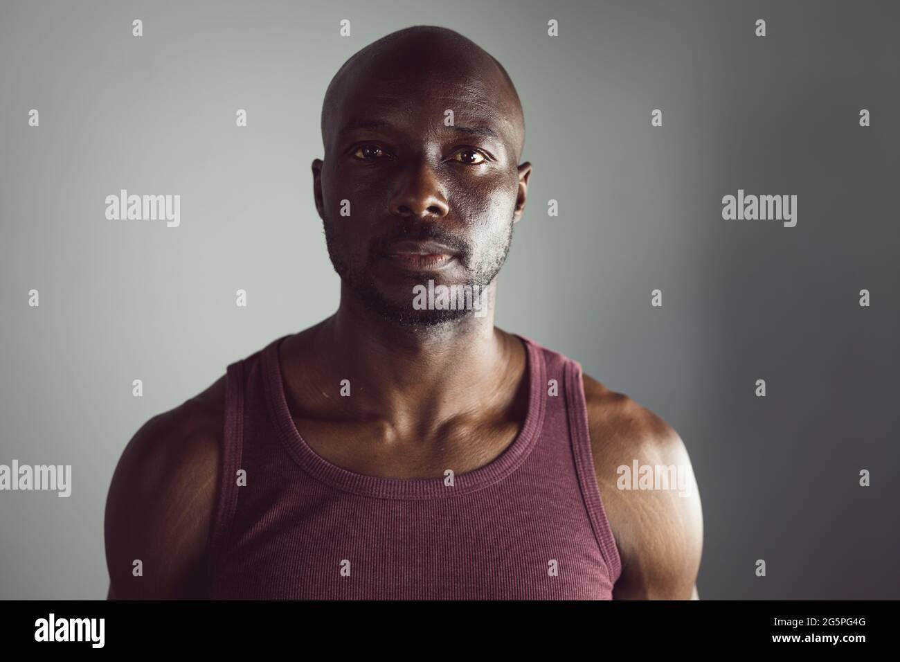 Porträt eines fitden afroamerikanischen Mannes, der im Fitnessstudio trainiert und direkt zur Kamera blickt Stockfoto