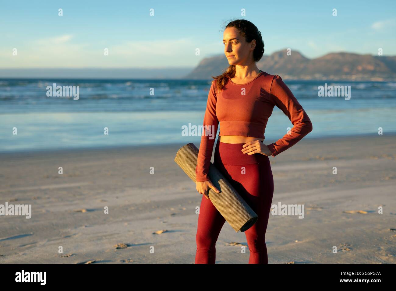 Portrait von kaukasischen Frauen, die Yoga praktizieren, am Strand stehen und Pause machen Stockfoto
