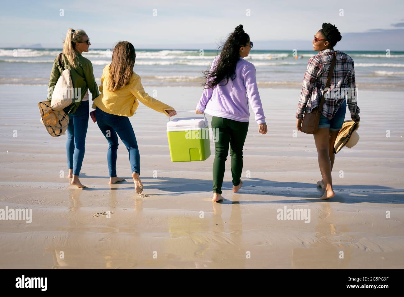 Fröhliche Gruppe von verschiedenen Freundinnen, die Spaß haben, am Strand entlang lachen Stockfoto