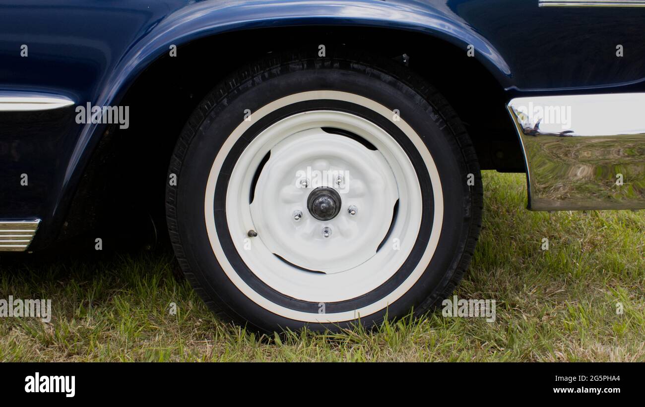 Ein einfaches Stahlrad und verchromte Ansatzmuttern an einem alten Auto Stockfoto