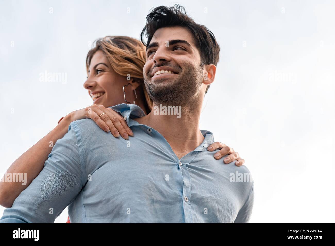 Ein paar junge Leute, die Spaß im Freien haben, umarmen sich zusammen. Stockfoto